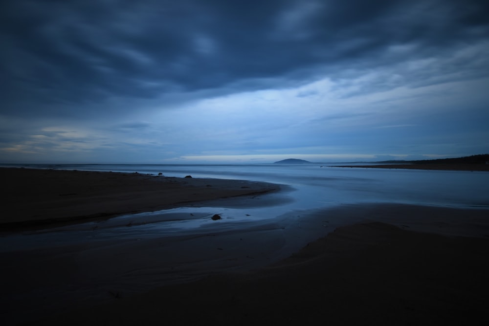 body of water under blue sky