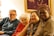 A diverse group of people watching a television together, smiling and enjoying a show.
