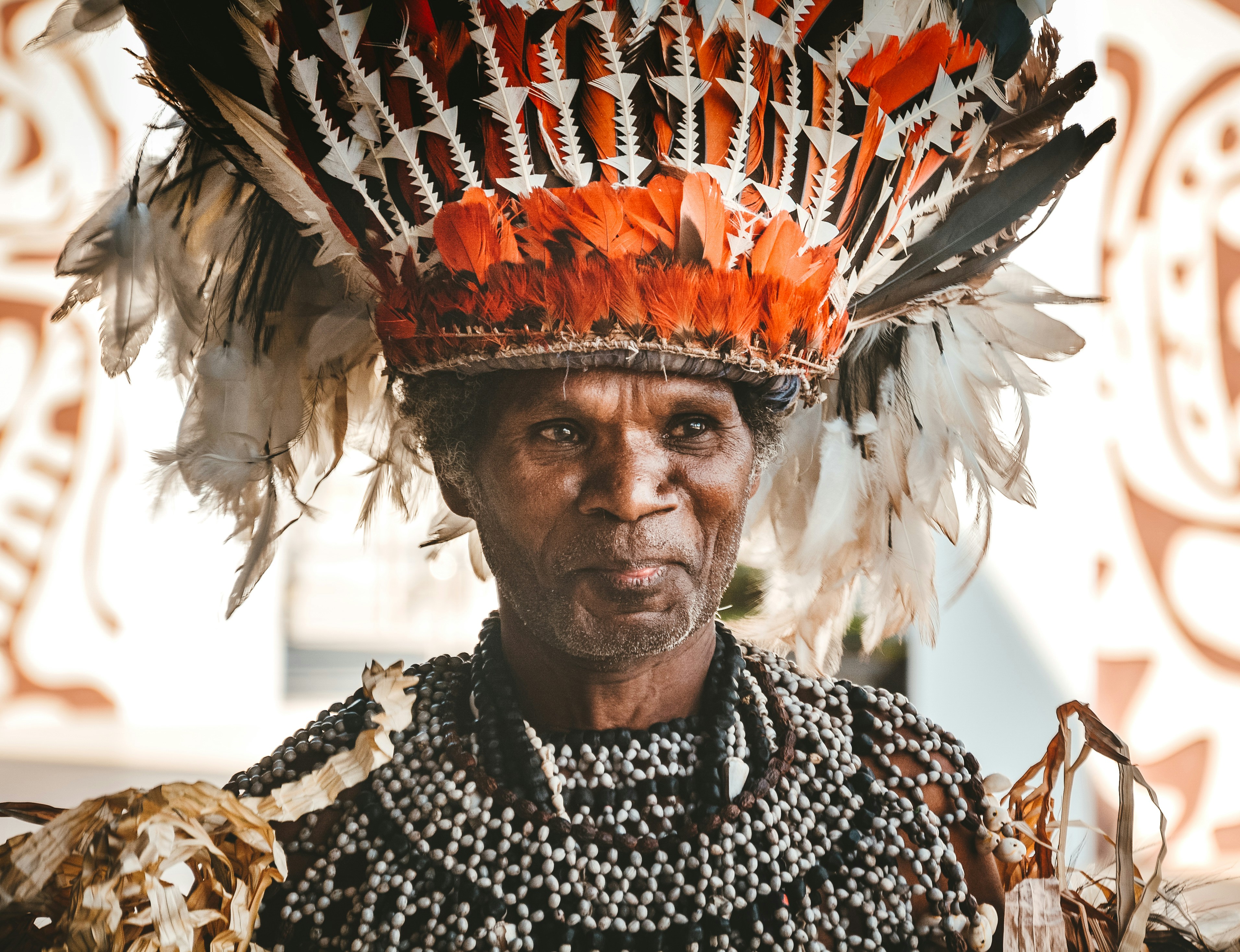 man wearing head dress guinea-bissau teams background