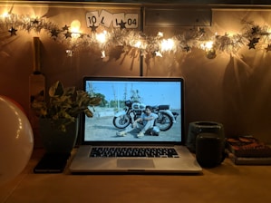 A warm, candid portrait of abdul qudoos musab in a cozy workspace surrounded by books and a laptop.