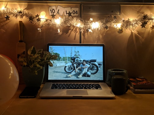 A cozy desk setup with a laptop, geek-themed decorations, and a cup of coffee.