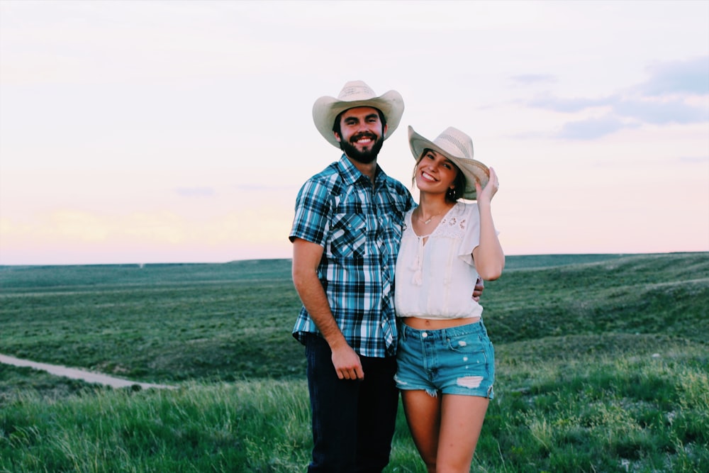 man and woman standing on grass field during daytime