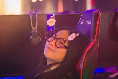 A cheerful gamer celebrating a victory with a headset on in a home environment.