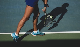 woman holding tennis ball and racket