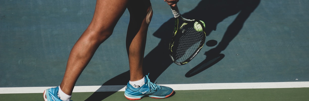 woman holding tennis ball and racket