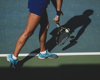 woman holding tennis ball and racket