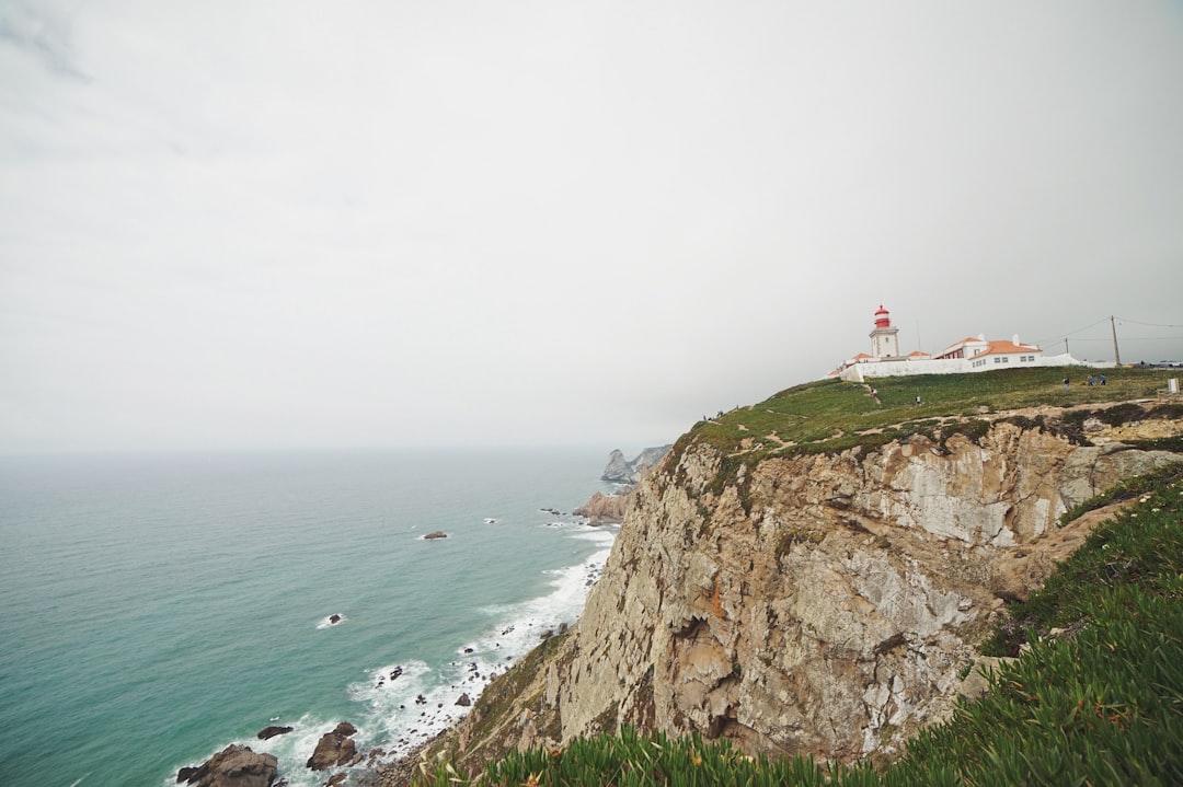 landscape photography of house near cliff shore