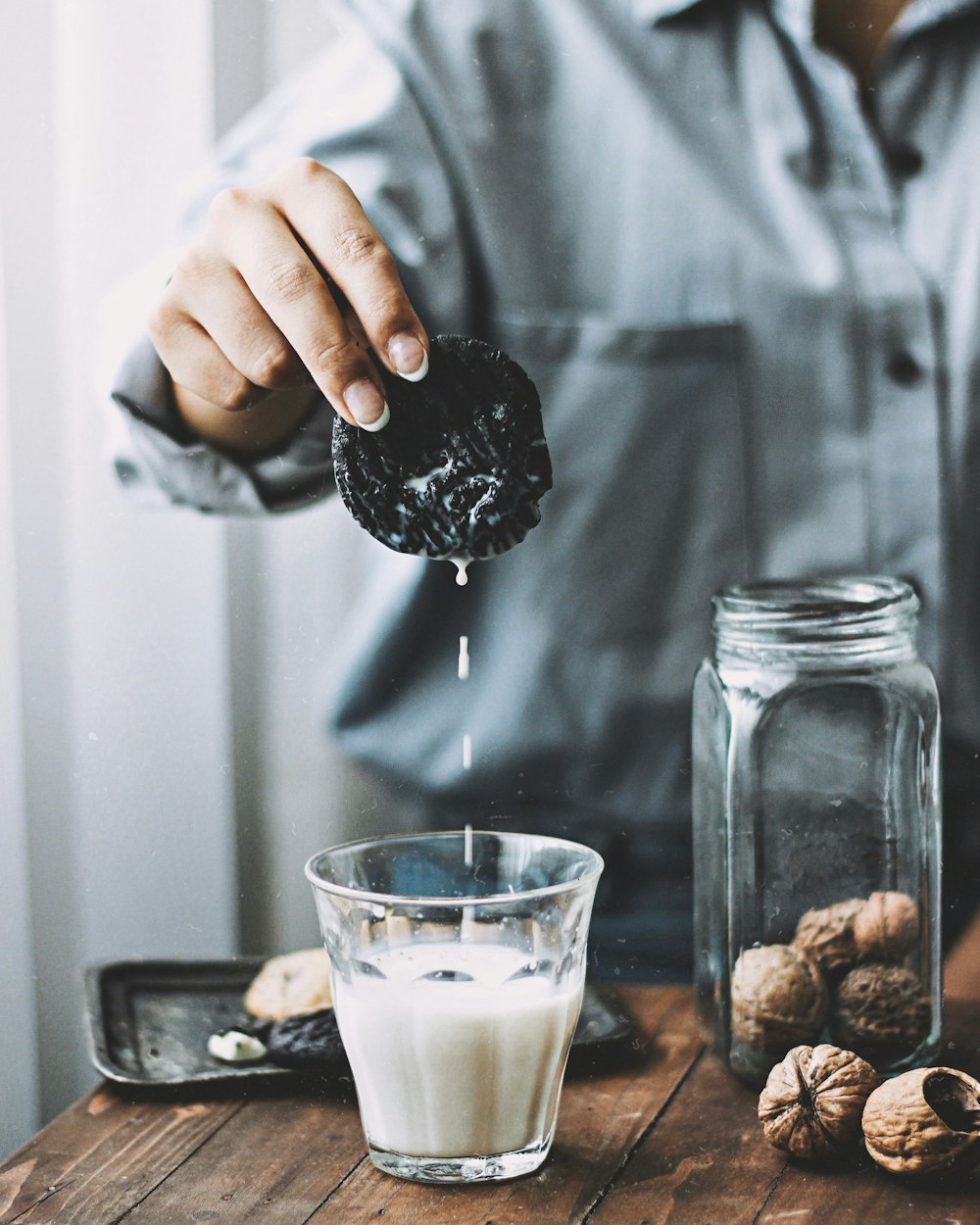 person dipping cookie in white liquid