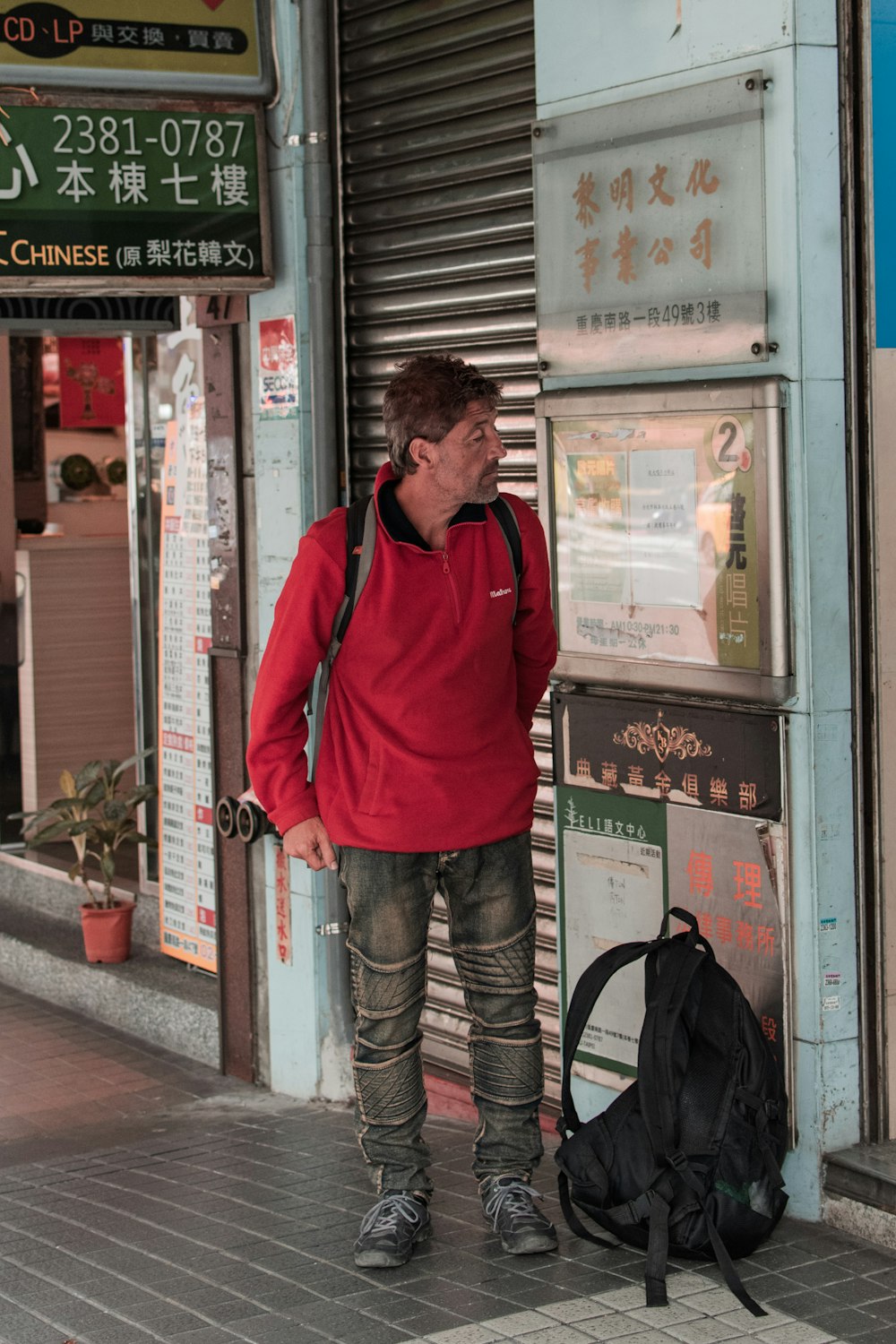 man standing near closed roller shutter