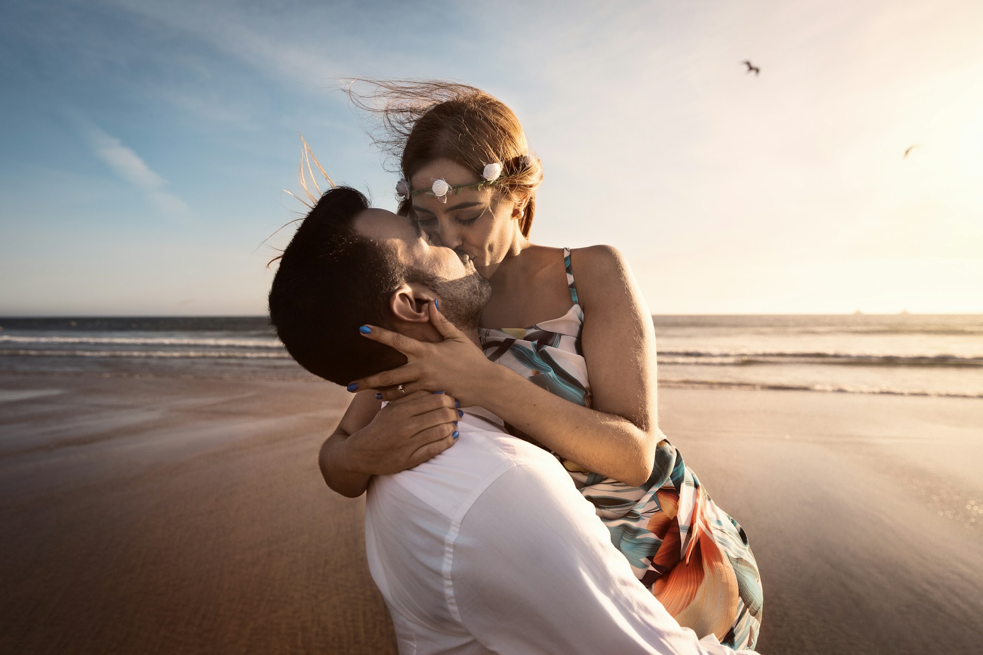 man and woman kissing on beach