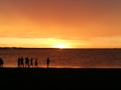 A group of happy travelers enjoying a sunset on the beach, reflecting the joy of their Bali experience.