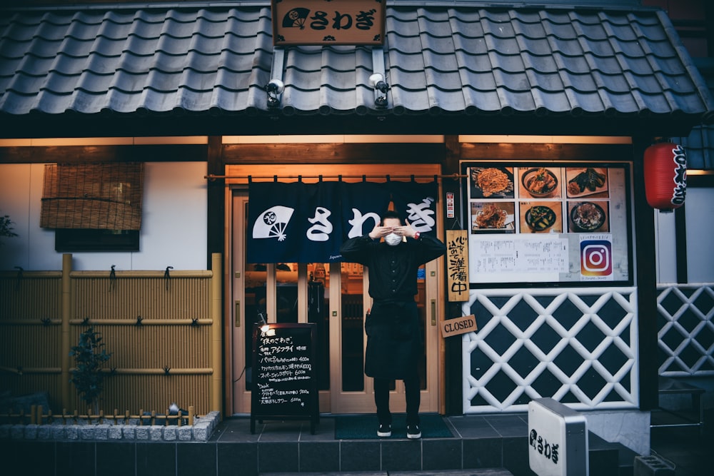 man standing in front of house