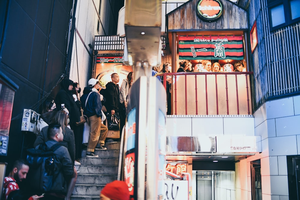 people standing on stairs going to building