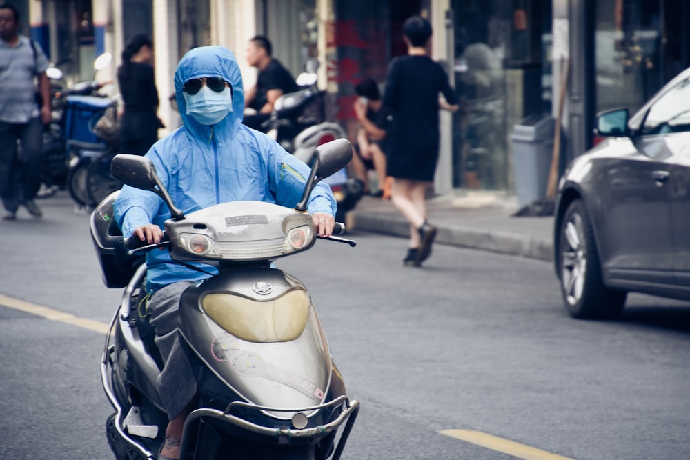 person driving motor scooter