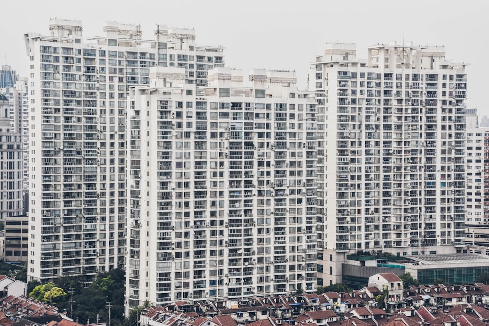 houses by mid-rise buildings during daytime