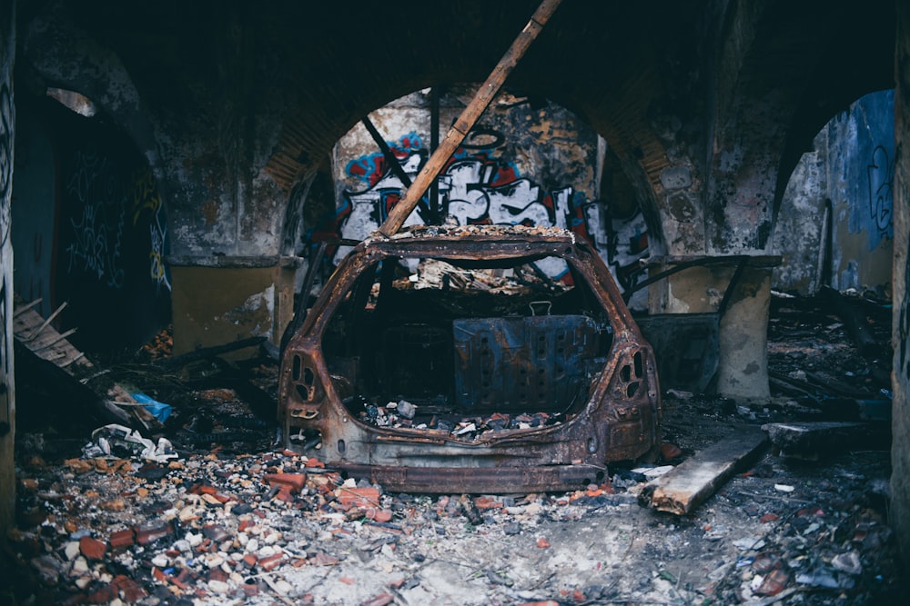 Vehículo destrozado dentro de un edificio abandonado