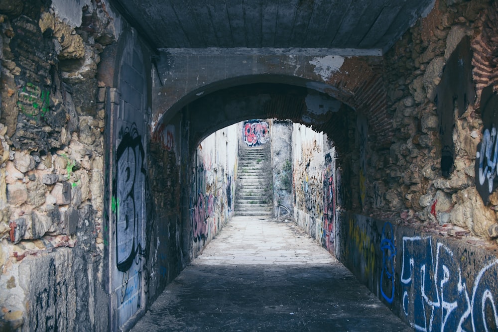 empty tunnel filled with graffiti during daytime