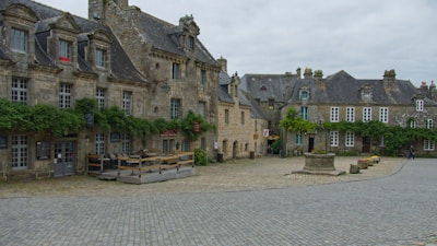 Quiet village square with ancient church and shaded benches.