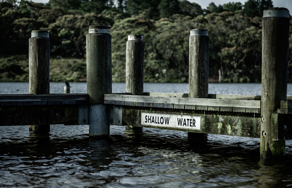a wooden dock with a sign that says shallow water