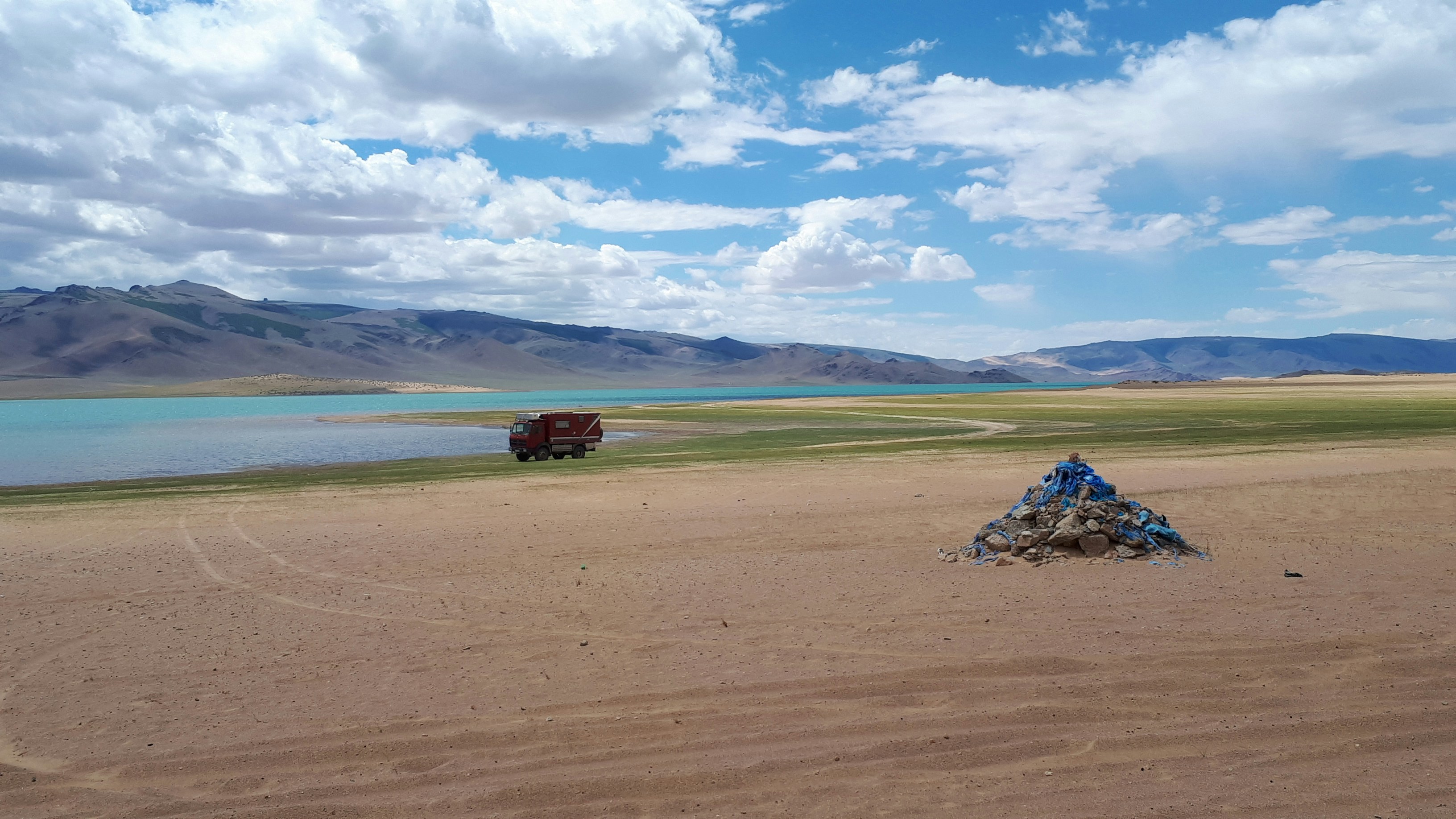 landscape photograph of vehicle near shore mongolia zoom background