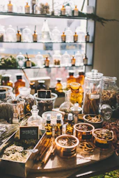 Glass apothecary shelves filled with jars of dried herbs