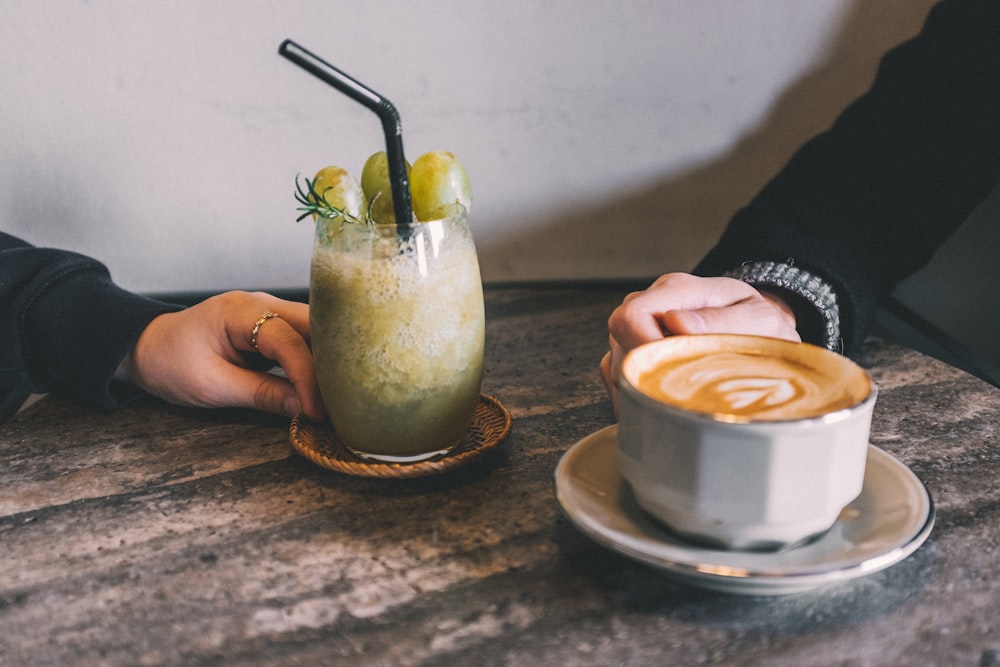 coffee latte beside juice glass