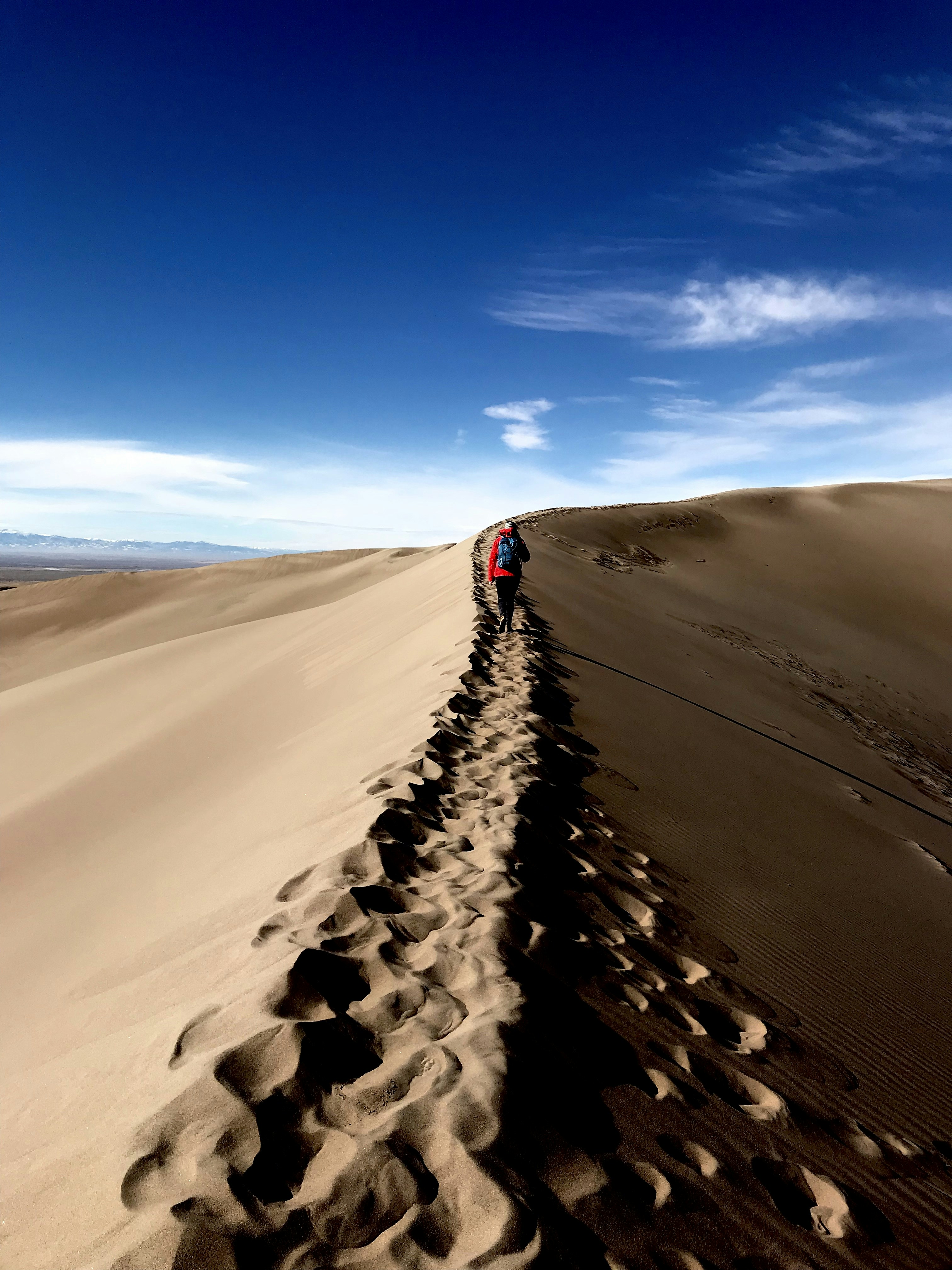 person walking on desert at daytime
