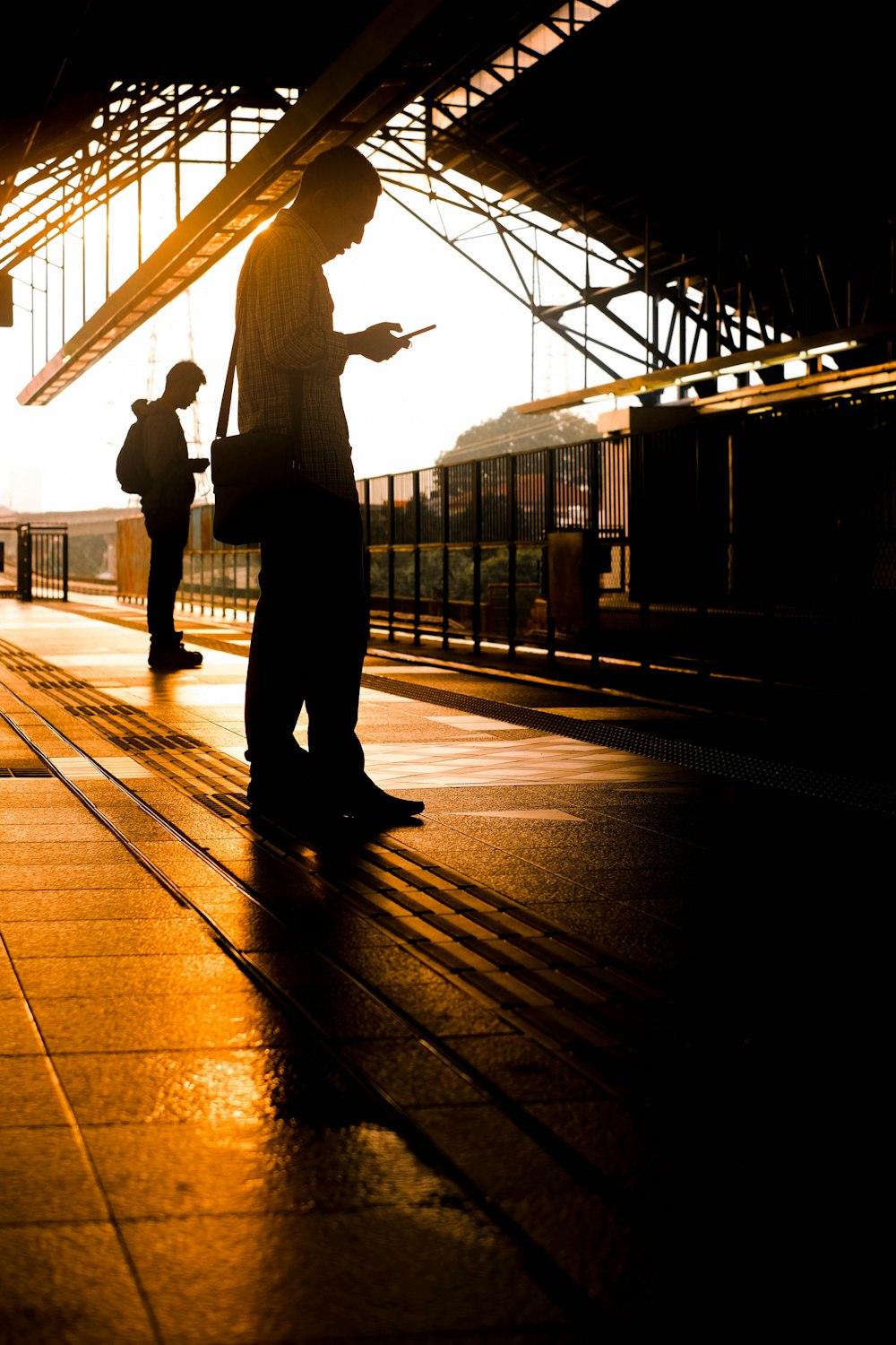 two men standing on train station