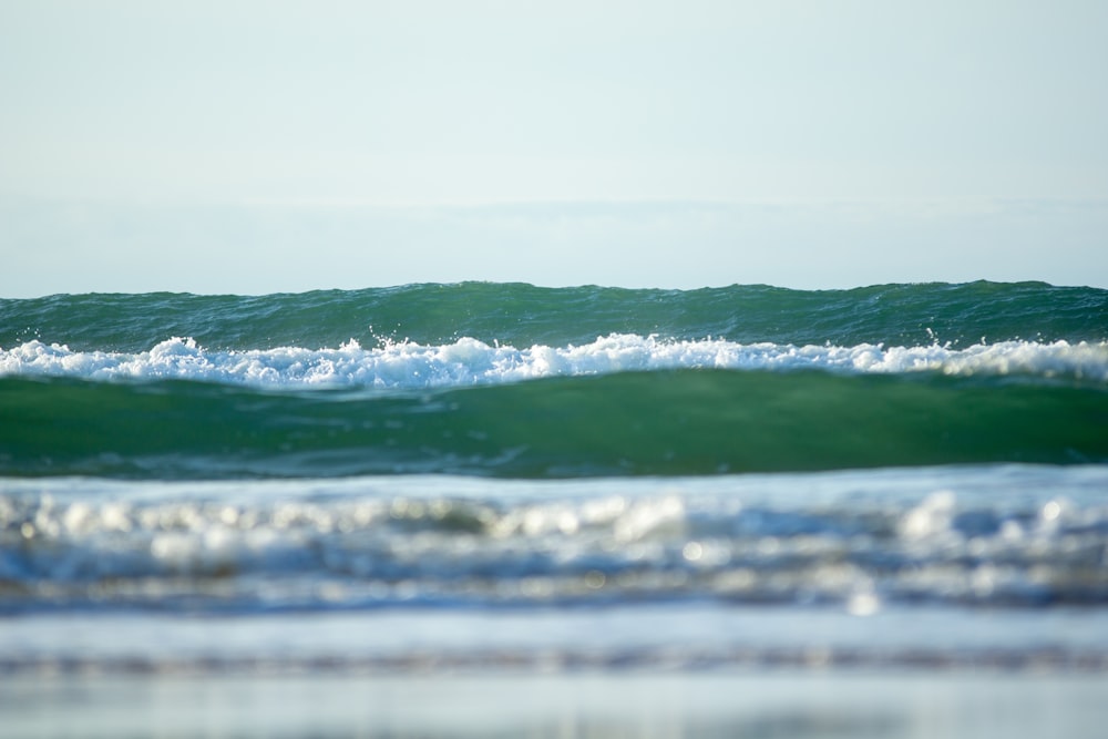 green ocean wave under blue sky