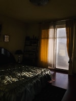 A softly lit bedroom corner with layered textiles and a bedside lamp.