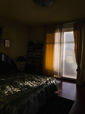 Bedroom with large windows and soft lighting.