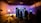 In a dimly lit studio, several silhouetted figures gather around an illuminated set piece resembling a futuristic corridor. Bright studio lights on stands cast shadows, and equipment like cameras and microphones are visible. The ceiling has an industrial look with exposed beams, and a ladder leans against the wall.