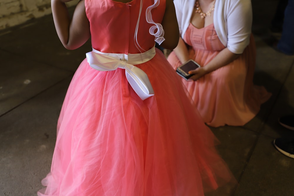 woman wearing pink dress while standing on floor