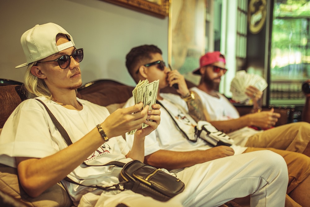 man sitting while counting dollars