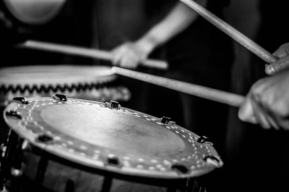 grayscale photo of person playing drums