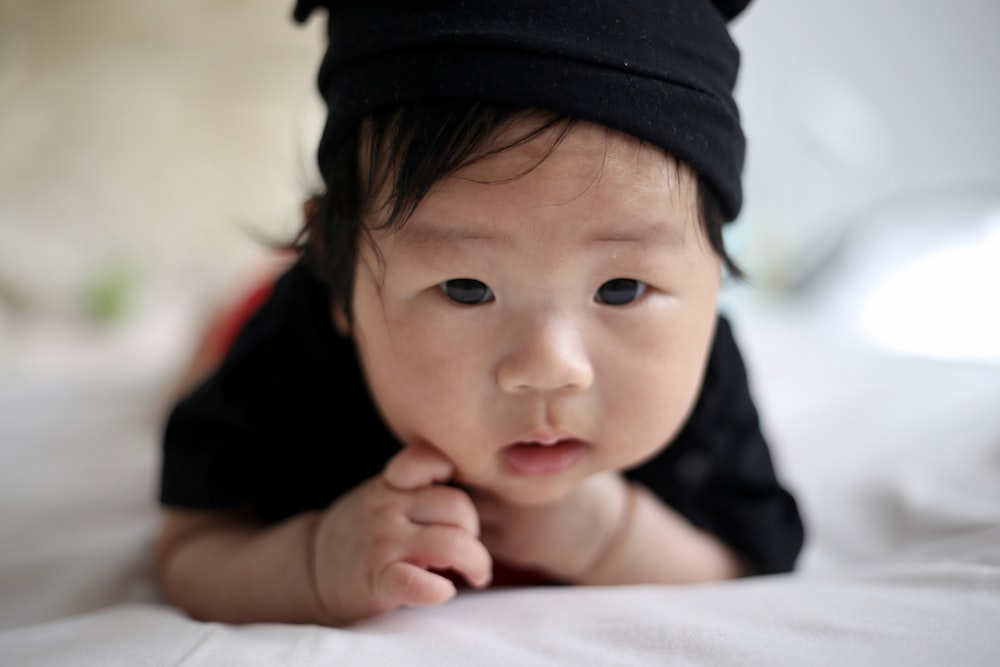 shallow focus photo of baby wearing black knit cap