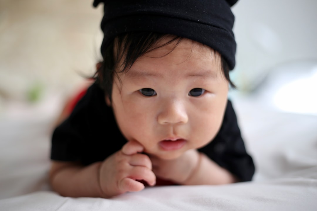 shallow focus photo of baby wearing black knit cap