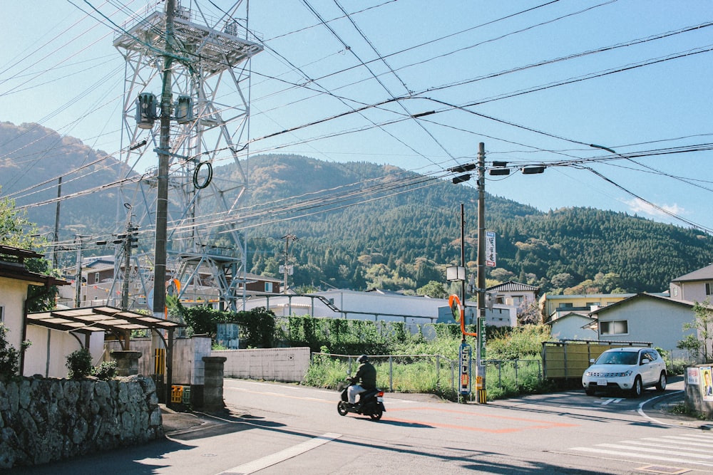 man riding on motor scooter under blue sky