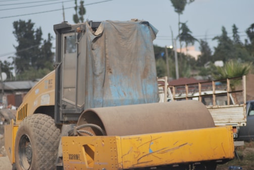 Instructor guiding a small group of students around a heavy-duty construction vehicle.