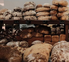 An assortment of freshly baked breads displayed on wooden shelves.