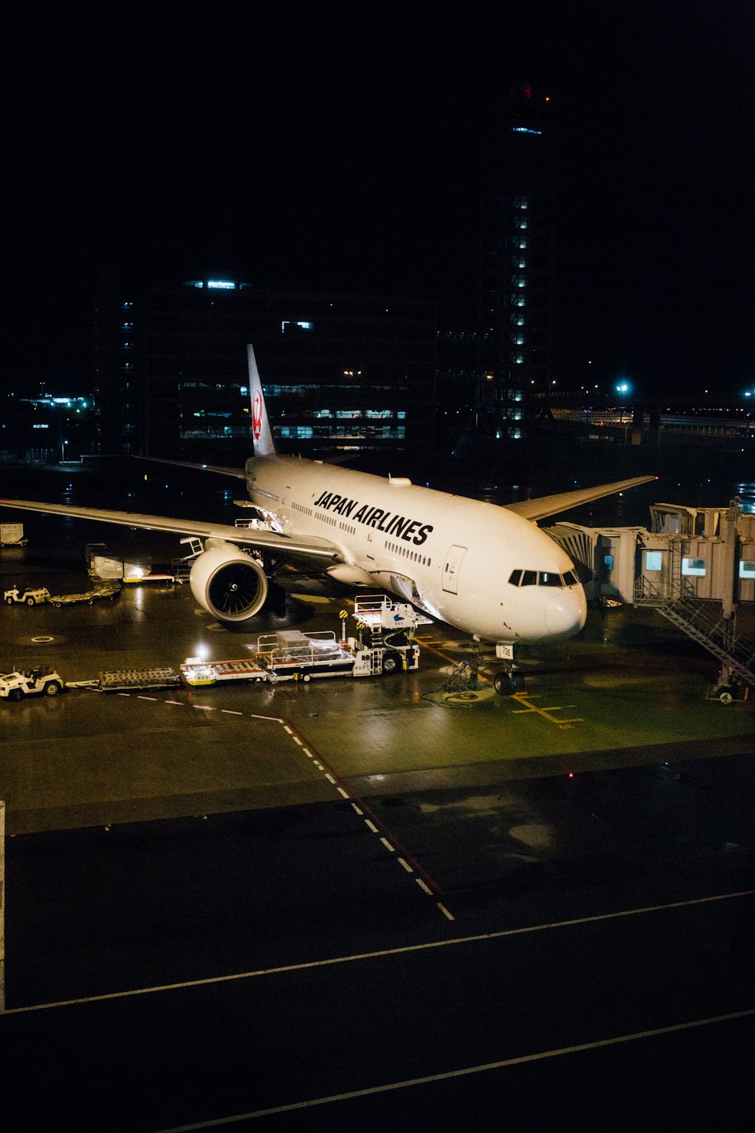 white Japan Airlines at airport during nighttime