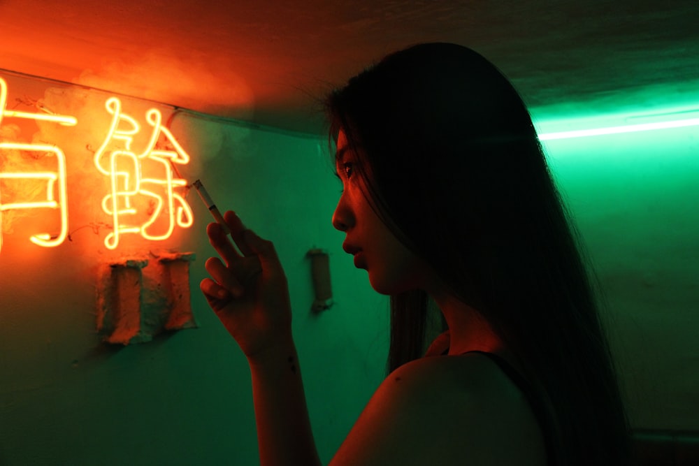 woman holding single cigarette inside room