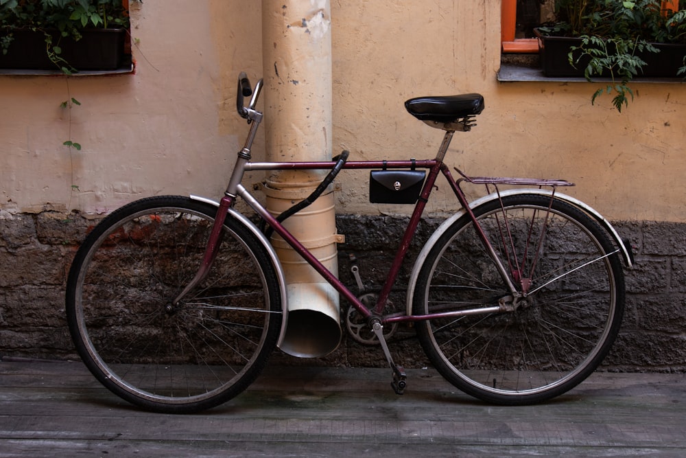 Bicicleta de cercanías marrón cerca de tubería beige