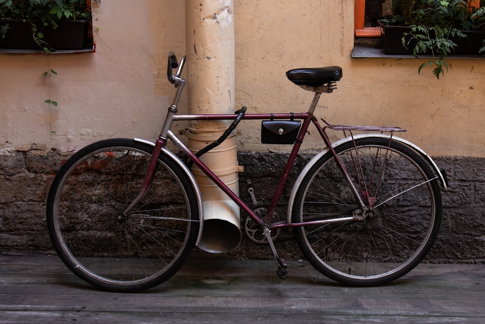 brown commuter bicycle near beige pipe