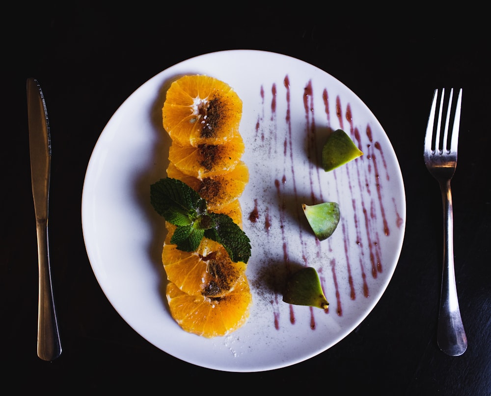 flat-lay photography of slice orange fruits on white plate