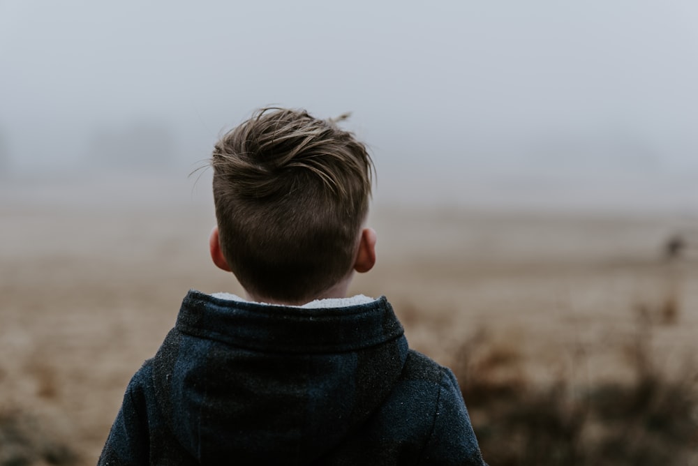 boy standing while wearing black hooded jacket