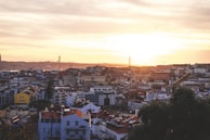 A panoramic shot of a metro viaduct stretching across an urban landscape at sunset.
