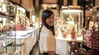 Smiling woman browsing clothes in a modern boutique setting.