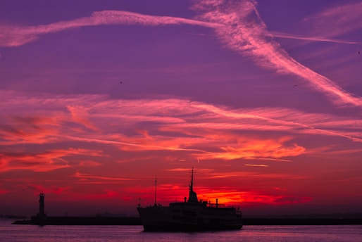 A vibrant sunset over the turquoise waters of Morro de São Paulo with a sleek lancha cruising by.