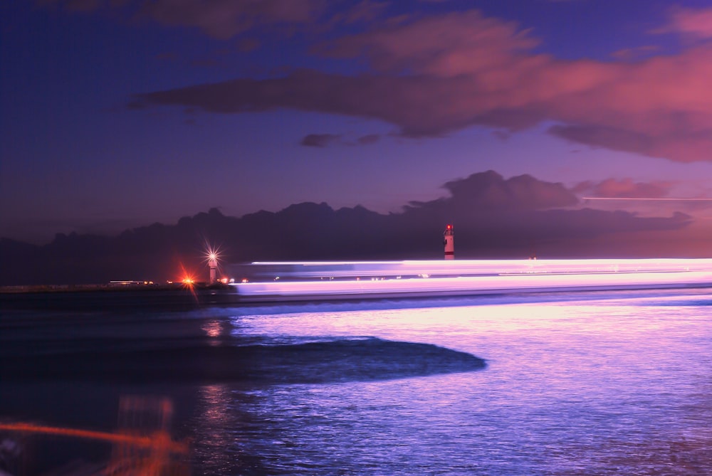 uma vista de um farol de uma praia à noite